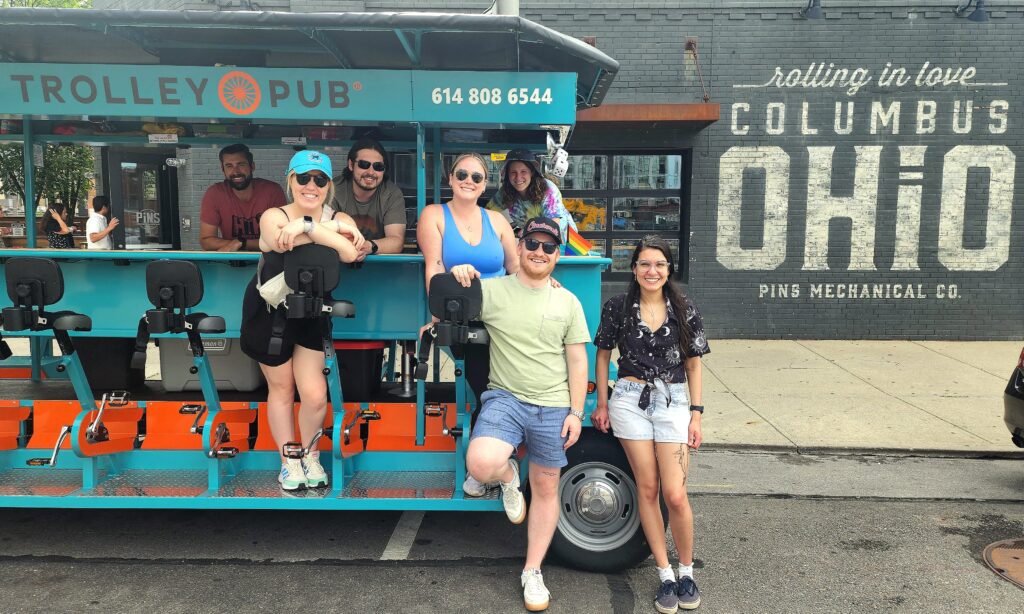Group of people posing in front of Trolley Pub during a party bike tours