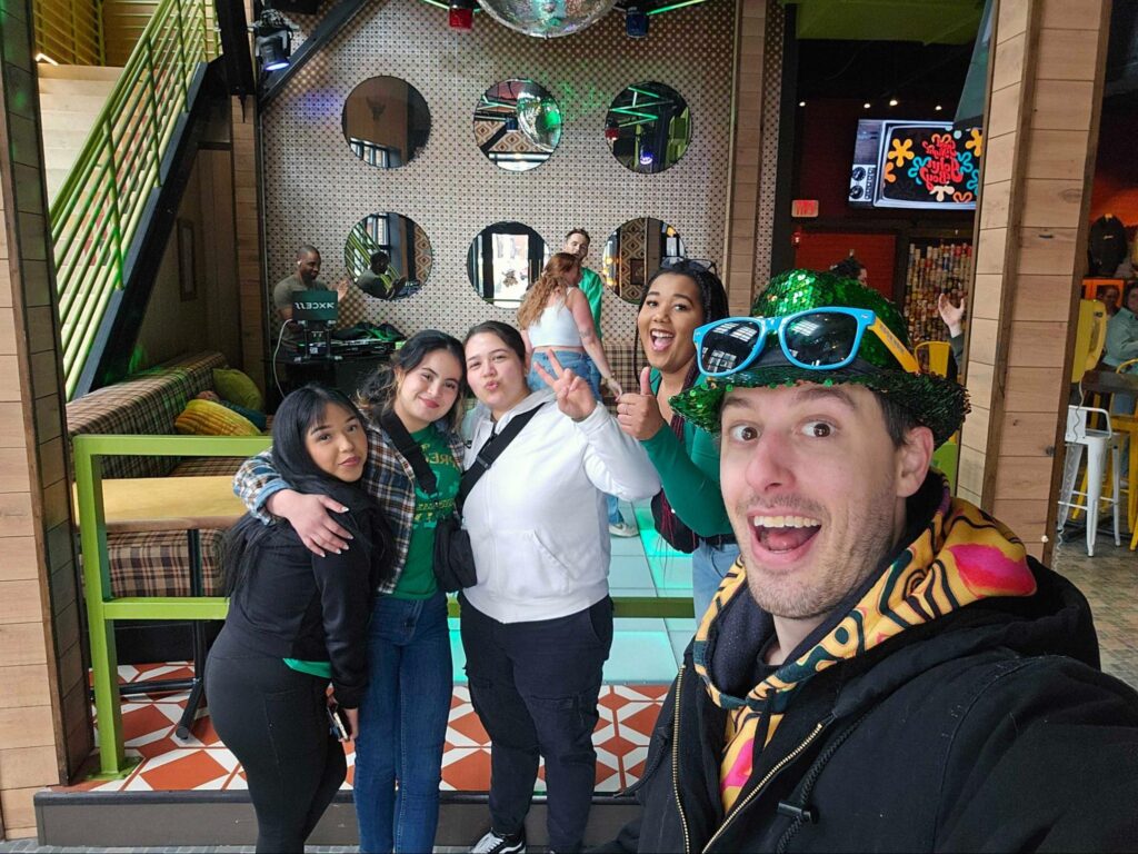 Group of people enjoying a festive gathering in a colorful indoor setting.