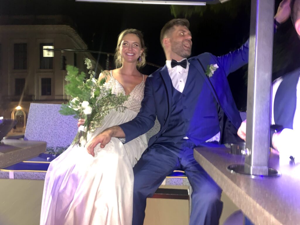 A couple in wedding attire sitting together at night.